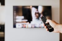 Programme TV ce soir vendredi 15 mai 2026 : main tenant une télécommande pointant vers un écran TV allumé