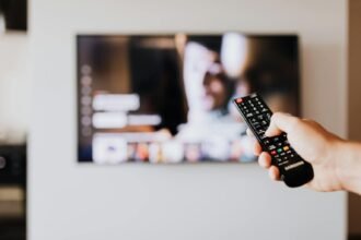 Programme TV ce soir vendredi 15 mai 2026 : main tenant une télécommande pointant vers un écran TV allumé