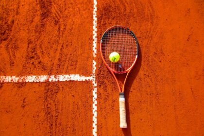 Raquette et balle de tennis sur terre battue rouge — Roland-Garros 2026