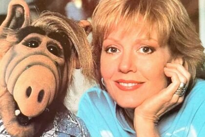 Anne Schedeen souriante aux côtés de la marionnette ALF