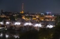 La Caverne du Pont Neuf de JR vue de nuit avec la Tour Eiffel en arrière-plan