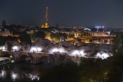 La Caverne du Pont Neuf de JR vue de nuit avec la Tour Eiffel en arrière-plan