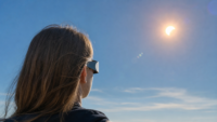 Personne observant une éclipse solaire avec des lunettes de protection