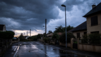 Orages dans le sud-ouest : 20 000 foyers privés d’électricité Rue résidentielle du Sud-Ouest après un orage, sous un ciel sombre et avec un éclairage public éteint