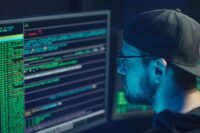 Expert en cybersécurité analysant des lignes de code sur plusieurs écrans