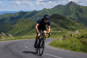Tour de france 2026 : l’étape aurillac–le lioran attend le peloton mardi 14 juillet Cycliste sur une route de montagne du Massif central
