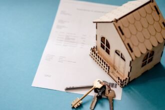 Modele de maison en bois, cles et contrat de pret pose sur une table