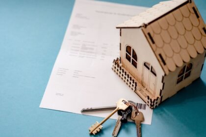 Modele de maison en bois, cles et contrat de pret pose sur une table