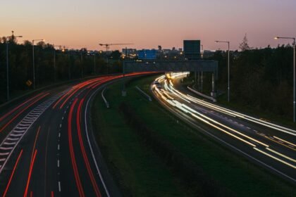 Autoroute urbaine au crépuscule, traînées lumineuses de véhicules