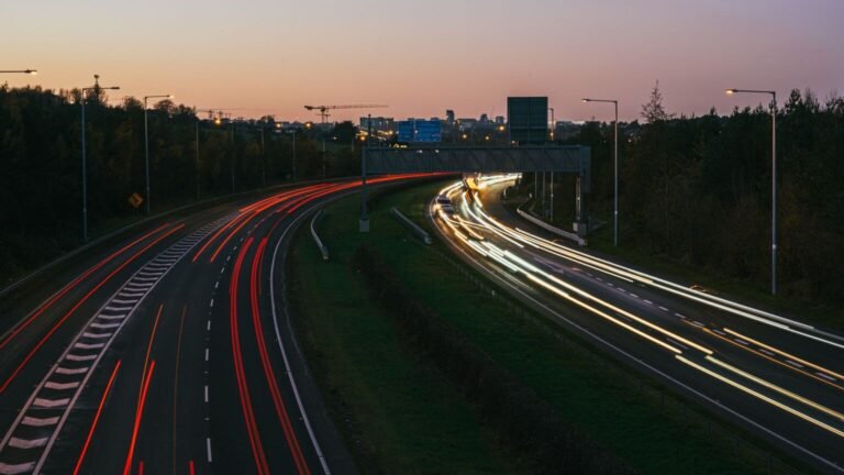 Autoroute urbaine au crépuscule, traînées lumineuses de véhicules