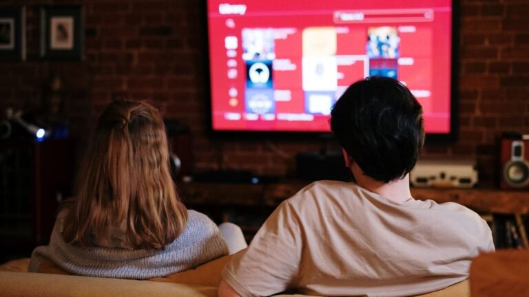 Un couple regarde une série en streaming sur un grand écran dans un salon