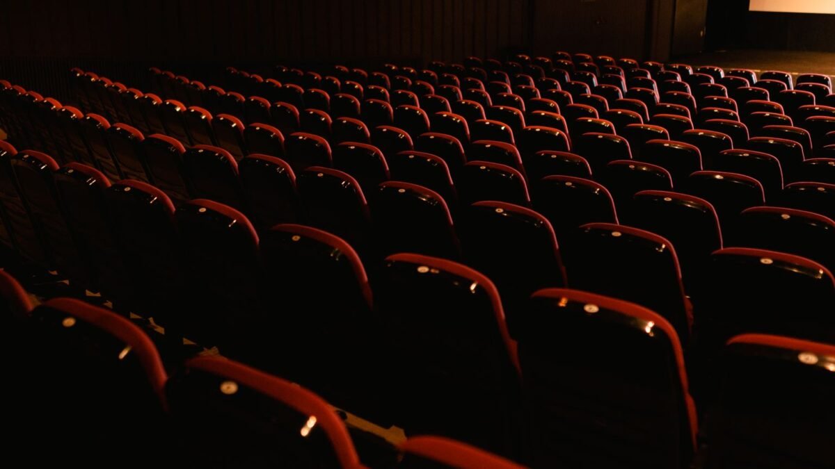 Rangées de fauteuils rouges vides dans une salle de cinéma