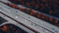 Vue aérienne d'une autoroute chargée entourée d'arbres d'automne