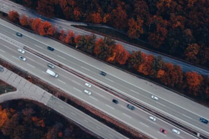 Vue aérienne d'une autoroute chargée entourée d'arbres d'automne
