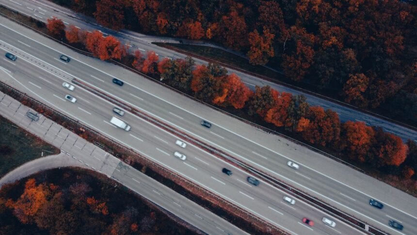 Bison futé ce week-end : samedi orange en île-de-france, a6, a10 et a13 Vue aérienne d'une autoroute chargée entourée d'arbres d'automne