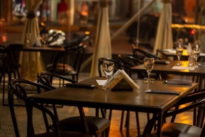 Salle de restaurant aux tables dressées, lumière chaude