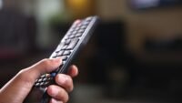 Main tenant une télécommande de télévision