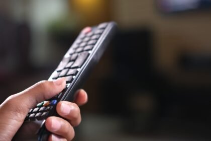 Main tenant une télécommande de télévision