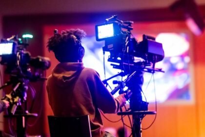 Opérateur de caméra filmé de dos dans un studio de télévision