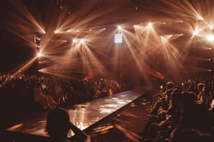Défilé de mode sous des éclairages dramatiques devant un public