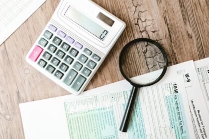 Calculatrice et loupe posées sur des documents fiscaux