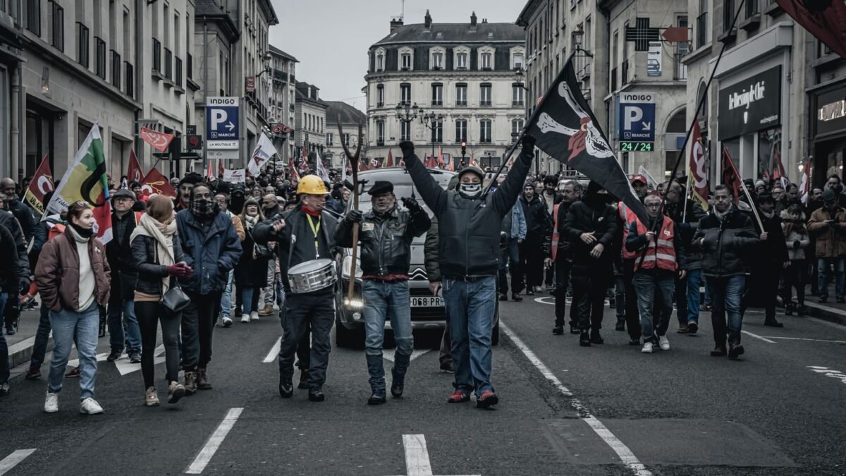 Manifestants défilant dans une rue avec drapeaux et banderoles