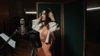 Chanteuse avec casque devant un micro dans un studio d'enregistrement