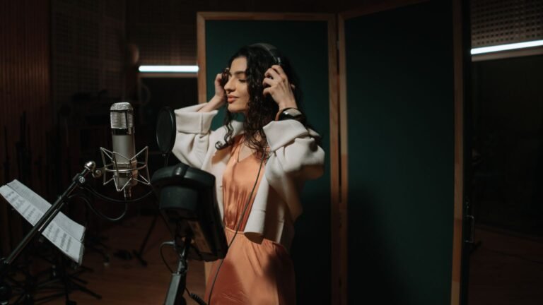 Mélina star academy : 22 ans, lozère, nommée après un couplet oublié Chanteuse avec casque devant un micro dans un studio d'enregistrement