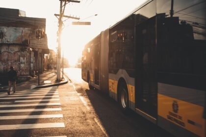 Un bus circule dans une rue de ville au coucher du soleil