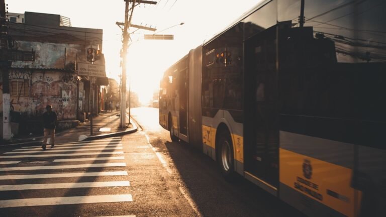 Grève à nantes vendredi : 12 lignes naolib perturbées, cars scolaires supprimés Un bus circule dans une rue de ville au coucher du soleil