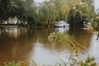Voiture dans une rue inondée après de fortes pluies, vigilance orange pluie-inondation
