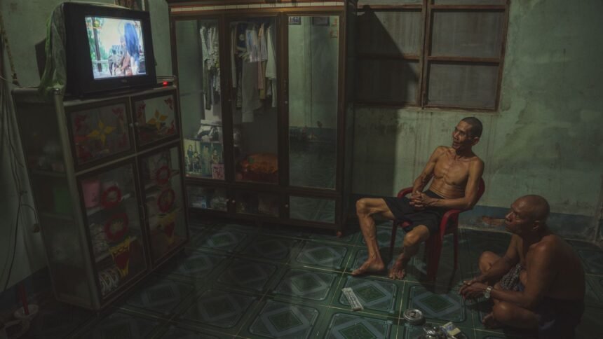 Deux hommes regardent la télévision dans un salon