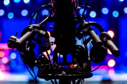 Silhouette d’une caméra de télévision devant des projecteurs de studio