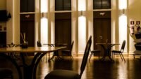 Cauchemar en cuisine à bertholène : le restaurant les palanges a fermé Salle de restaurant vide éclairée, chaises et tables en bois