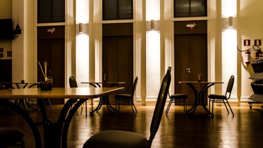 Cauchemar en cuisine à bertholène : le restaurant les palanges a fermé Salle de restaurant vide éclairée, chaises et tables en bois