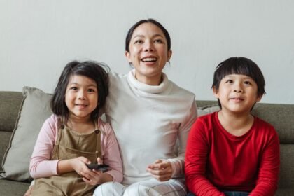 Famille regardant la télévision le soir, photo d’illustration