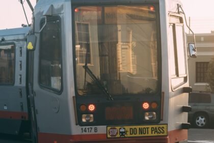 Un tramway moderne circule dans une rue de ville au coucher du soleil